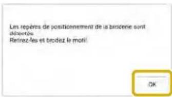 Les repères de positionnement de la broderie sont déjectés Retirez-les et brodez le motil OK