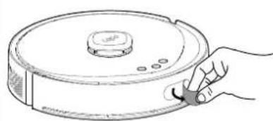 Line drawing of a hand holding a cleaning tool next to a circular device (no text or symbols)