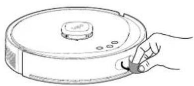 Line drawing of a hand holding a cleaning brush next to a circular device (no text or symbols)