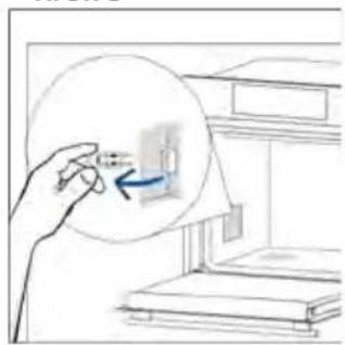 Hand holding a magnified inset showing a small object inside a room with bookshelves (no text or symbols visible)