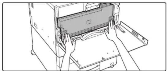 Line drawing of hands operating a printer with a cover (no text or symbols)