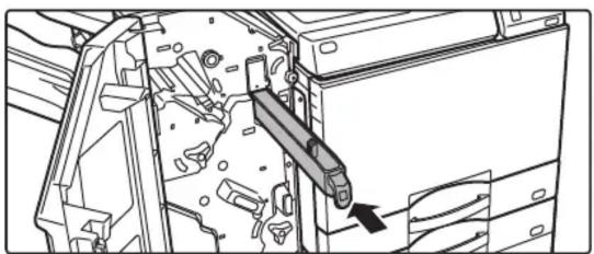 Technical line drawing of a mechanical assembly with a tool inserted, showing internal components and a directional arrow (no text or symbols)