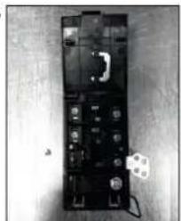 Black-and-white photo of an electronic device with visible ports and a small white label on the right (no readable text or symbols)