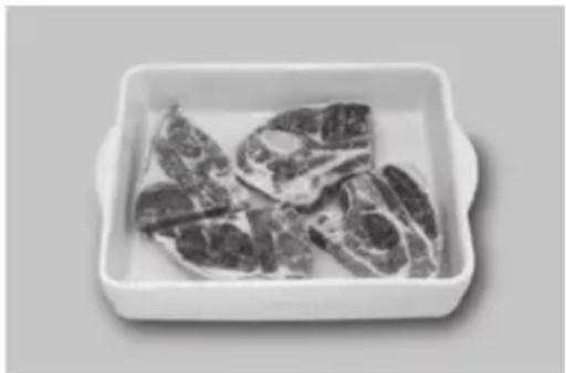 Black-and-white photo of raw meat pieces in a rectangular white bowl (no text or symbols visible)
