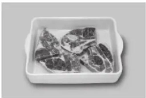 Box of raw meat pieces, likely pork ribs or cutlery, presented in a white ceramic dish (no text or symbols visible).