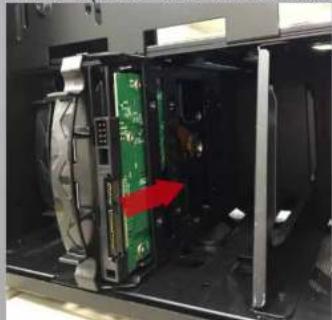 Interior view of a computer room showing a green electronic device with a red indicator box, no visible text or symbols