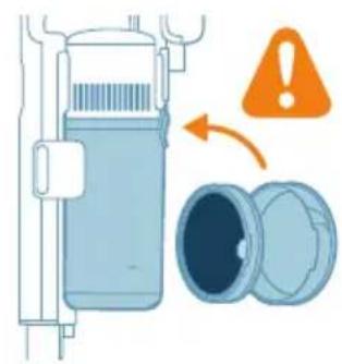 Illustration of a cylindrical device with internal components and an open lid, accompanied by an orange warning symbol (no text or labels).
