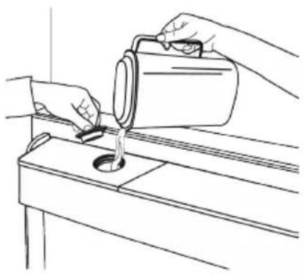 Line drawing of hands pouring liquid from a container onto a workbench (no text or symbols)