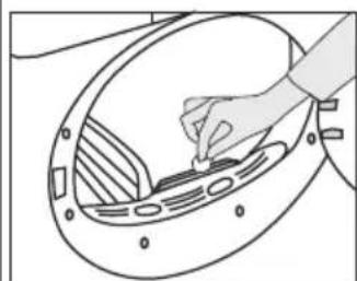 Line drawing of a hand placing a small object into a circular component (no text or symbols)
