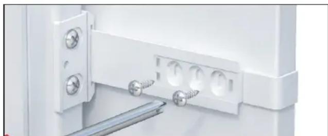 Close-up of a white plastic door hinge with screws and mounting holes (no text or symbols visible)