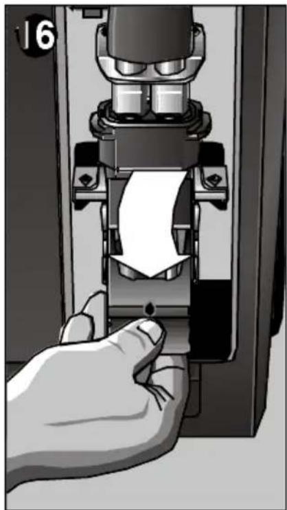 Hand pressing down a mechanical component with a paper sheet, no visible text or symbols.