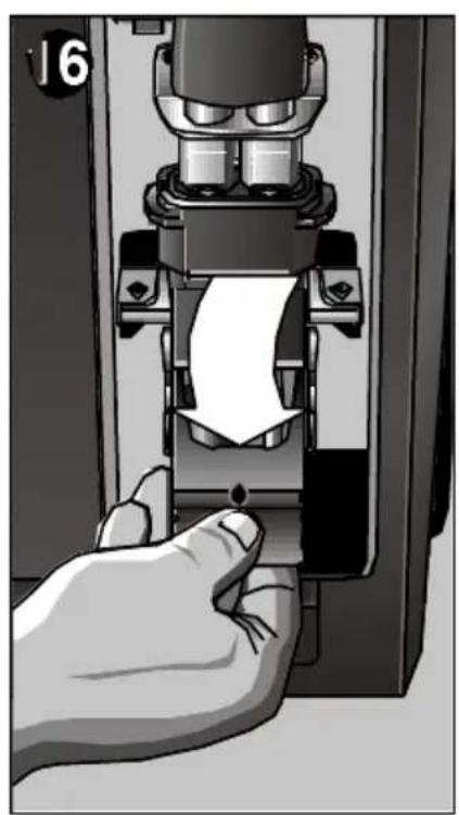 Hand pressing down a mechanical component with a paper sheet, no visible text or symbols.