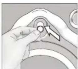 Close-up of a hand adjusting a circular component with a directional arrow (no text or symbols visible)
