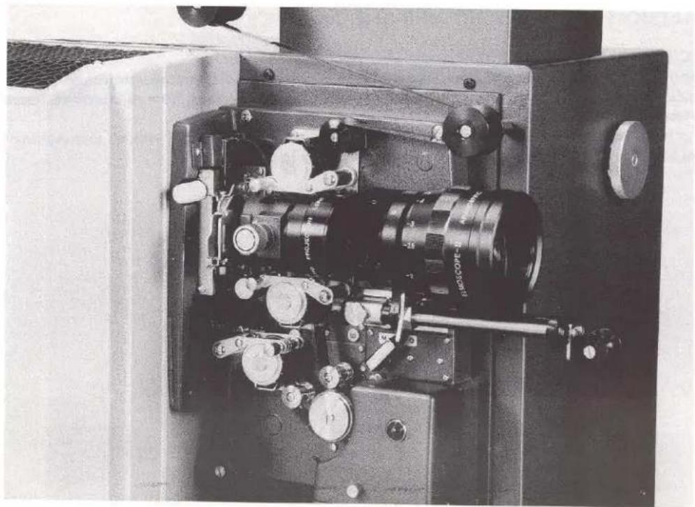 Close-up of a mechanical optical instrument with visible gears and components (no text or symbols)