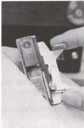 Close-up of hands using a handheld tool to adjust or install a mechanical component (no visible text or symbols)