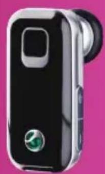 Black and white handheld device with a green circular logo on the front, against a pink background (no text or symbols visible).