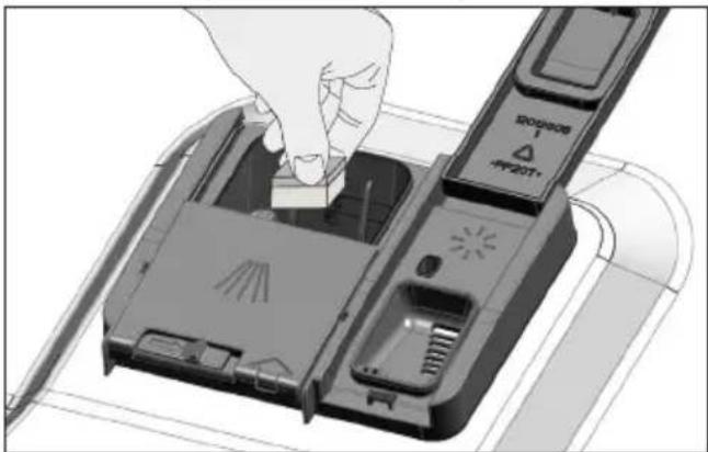 Illustration of a hand inserting a device into a device casing (no text or symbols visible).