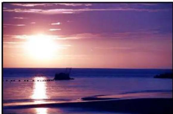 Sunset over the ocean with silhouetted boats and calm water reflection (no text or symbols)