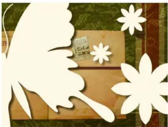 Decorative paper-cut art featuring a butterfly silhouette, floral motifs, and a small card on a wooden surface (no text or symbols)