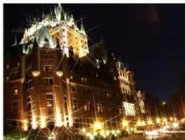 Nighttime exterior view of a historic stone building with illuminated spires and surrounding streetlights (no visible text or signage)
