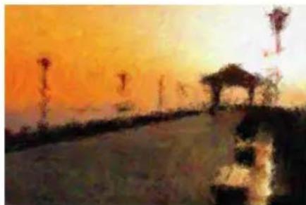 Sunset over a paved path with illuminated streetlights and a small pavilion (no visible text or symbols)