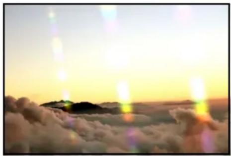 Aerial view of a mountain range above clouds during golden hour, with no visible text or symbols.