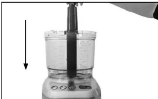 Close-up of a kitchen blender with a black tool inserted, showing liquid and control buttons (no text or symbols visible)