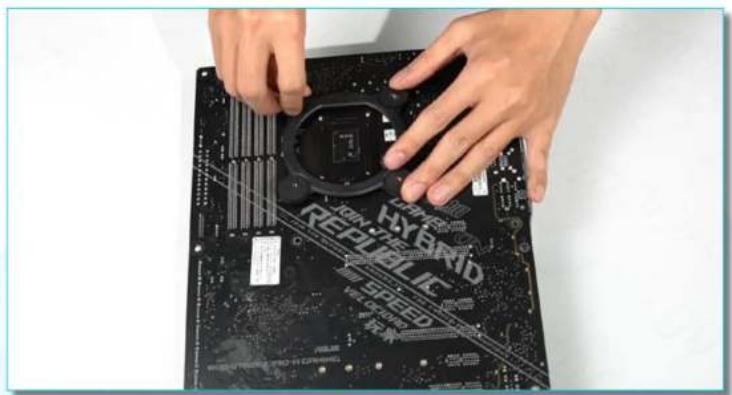 Close-up of hands installing a black CPU socket on a motherboard with visible branding (no text or symbols on the chip itself)