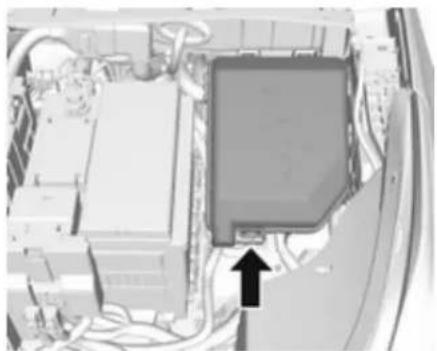Interior view of a vehicle showing a rectangular component with an arrow pointing to it, surrounded by wiring and equipment (no visible text or symbols)