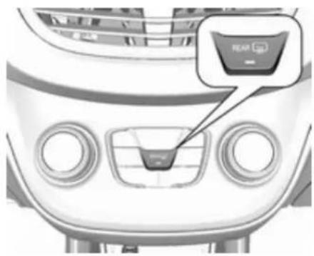 Front view of a car dashboard with control buttons and a highlighted 'REAR' button (no text or symbols on the main subject)