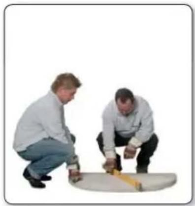 Two men measuring a large cylindrical object, one crouching and the other kneeling (no text or symbols visible)
