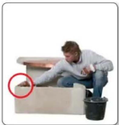 Man cleaning a wall-mounted device with a bucket nearby (no text or symbols visible)