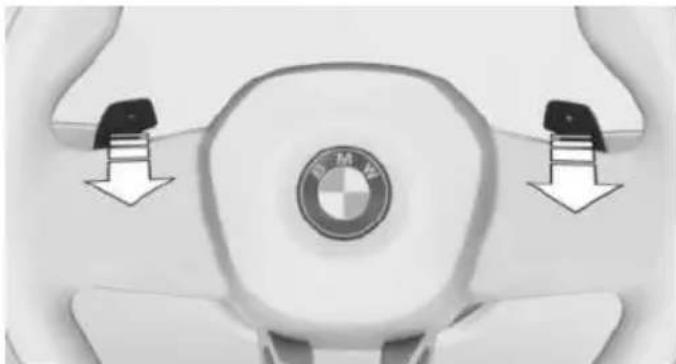 Top-down view of a BMW car steering wheel with two directional arrows indicating clockwise motion (no text or symbols)