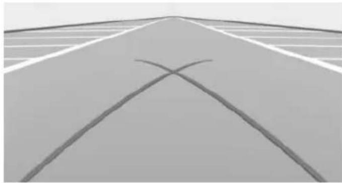 Exterior view of a modern road with intersecting white painted lines forming an X shape (no text or symbols)