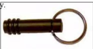 Close-up of a dark cylindrical object with a metallic ring attached, resembling a key or connector (no text or symbols visible)