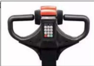 Top-down view of a black exercise bike head with orange handle and control panel (no text or symbols visible)