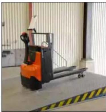Industrial forklift on a metal platform in a warehouse setting (no visible text or symbols)