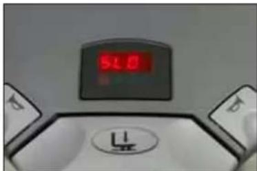 Close-up of a digital kitchen scale with a red LED and circular button (no visible text or symbols)