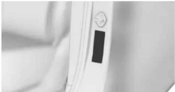 Close-up of a white door with a black rectangular button and circular dial (no visible text or symbols)