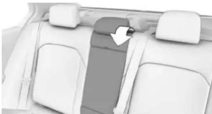Interior view of a car showing seatbelt and rear seats with a white arrow pointing to the seat (no text or symbols visible)