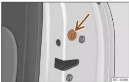 Close-up of a car's front panel showing a smiley face with a small orange circle and a brown arrow pointing to it (no text or symbols)