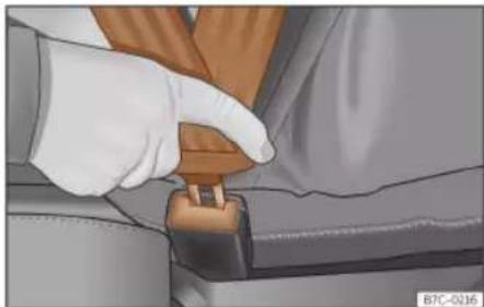 Close-up of a gloved hand adjusting a seatbelt buckle (no text or symbols visible)