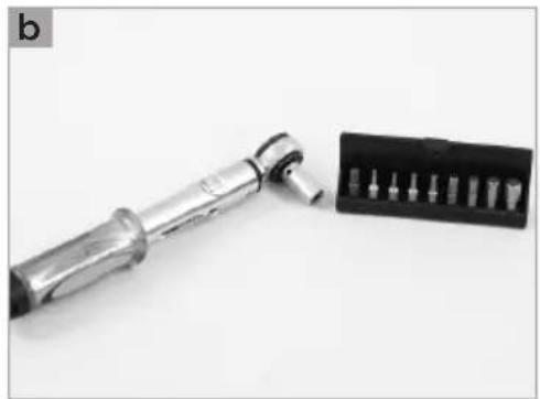 Close-up of a metallic tool with a black plastic tray containing multiple screw holes (no text or symbols visible)