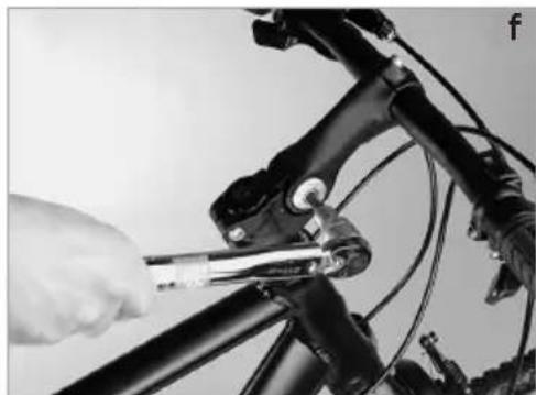 Close-up of a bicycle's front wheel being adjusted using a tool (no text or symbols visible)