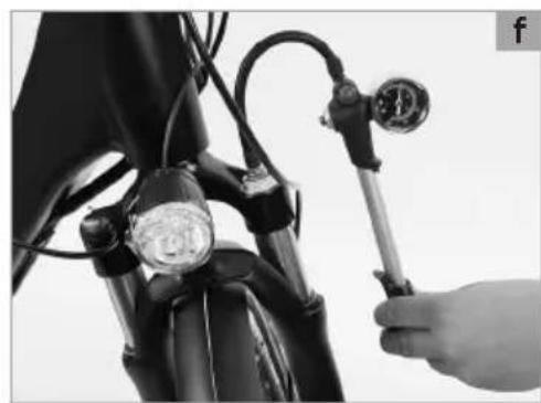Close-up of a hand adjusting a pressure gauge on a motorcycle's seat (no visible text or symbols)