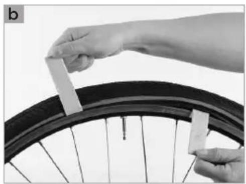 Close-up of hands installing a bicycle tire with plastic clips (no text or symbols visible)
