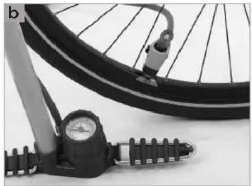 Close-up of a bicycle tire with a pressure gauge and mechanical components (no visible text or symbols)