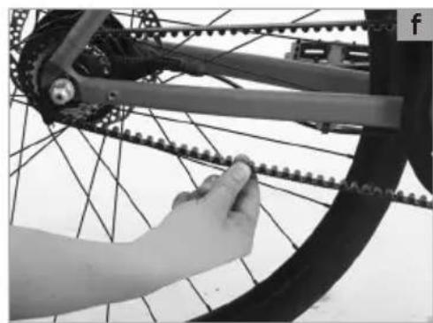 Close-up of a hand adjusting a bicycle chain on a wheel (no text or symbols visible)