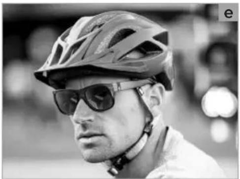 Black-and-white photo of a person wearing a cycling helmet and sunglasses (no visible text or symbols)