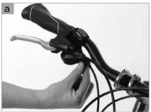 Close-up of a hand holding a bicycle brake lever with a white handle (no text or symbols visible)